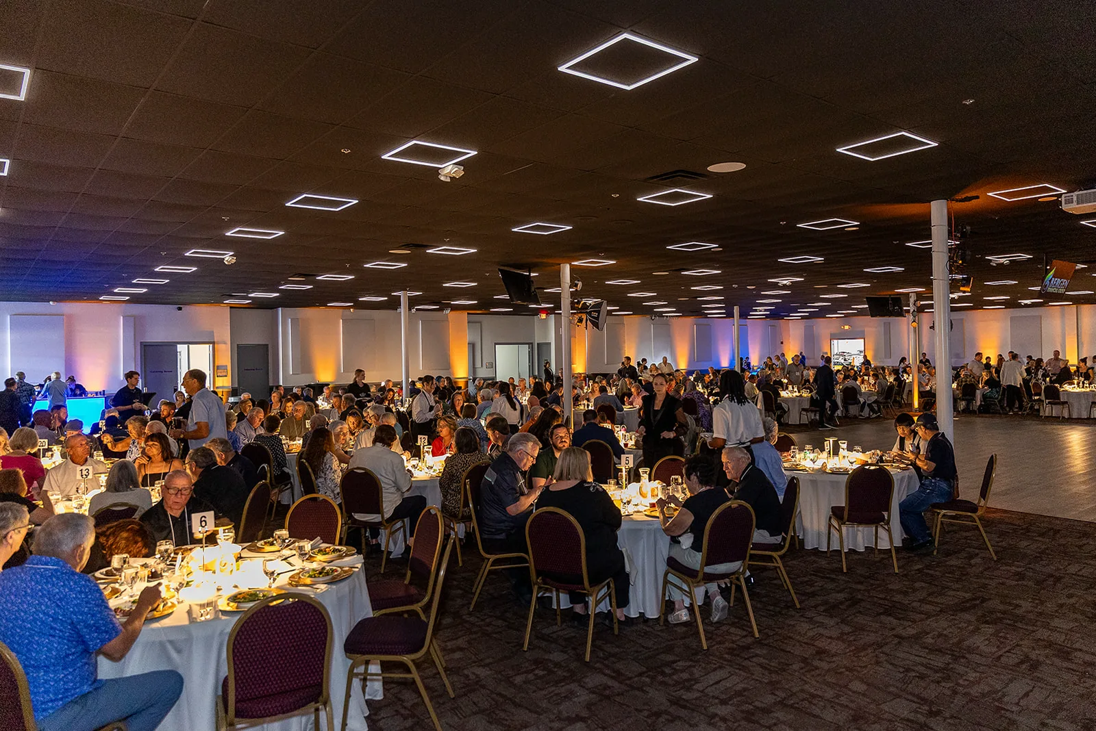 A full ballroom of guests seated for dinner