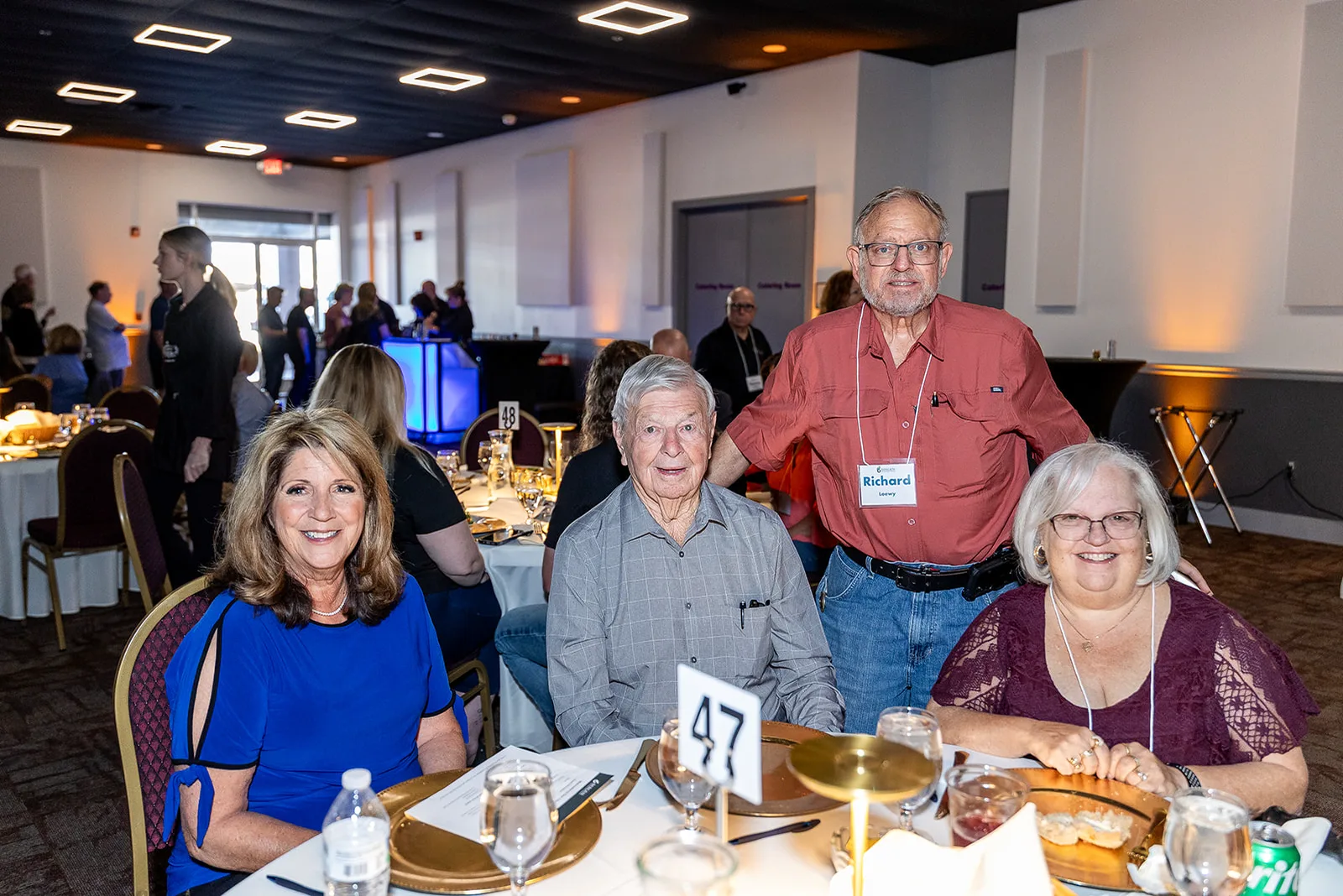 Guests smiling at their table during a car club dinner